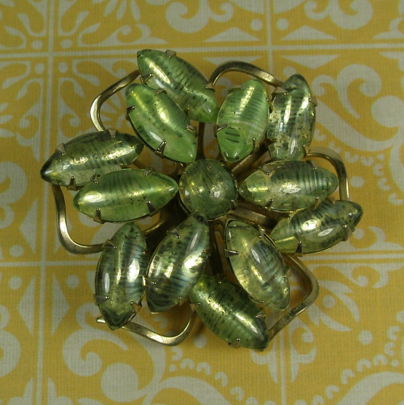 Interesting green stoned snowflake brooch