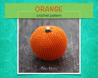 May include: An orange crochet pumpkin with a green and white stem. The image includes the text "ORANGE crochet pattern" in a green banner. The pumpkin is sitting on a wooden surface.