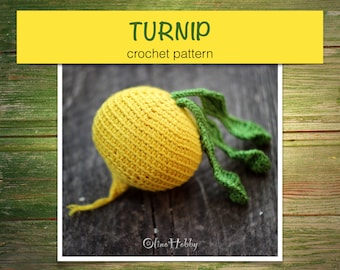 May include: A crocheted yellow turnip with green leaves. The turnip is sitting on a wooden surface. The text "TURNIP crochet pattern" is written on a yellow banner above the turnip.