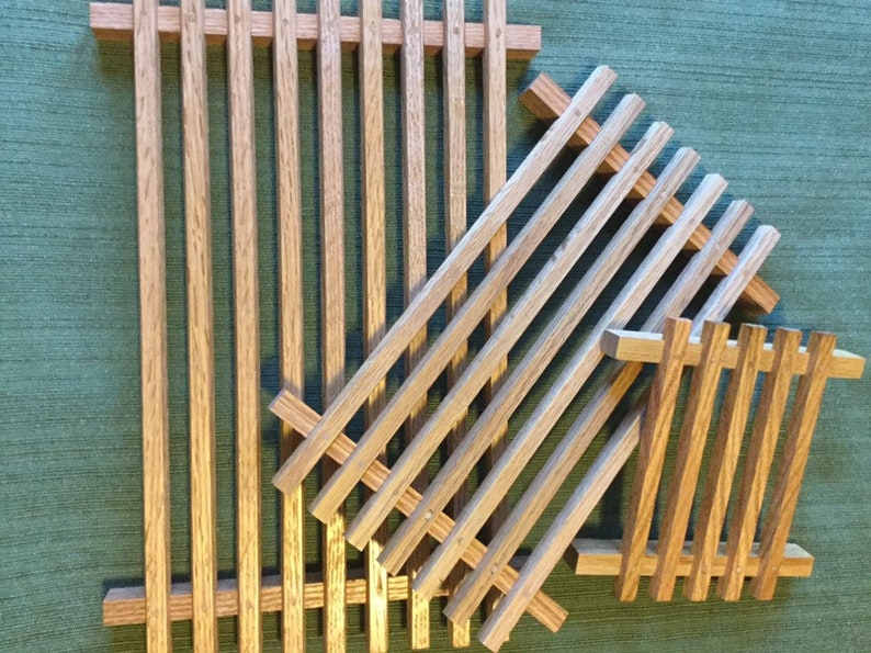 Puede incluir: Tres bandejas de madera con listones de diferentes tama&ntilde;os, apiladas una encima de la otra. Las bandejas son de madera natural de color marr&oacute;n claro.