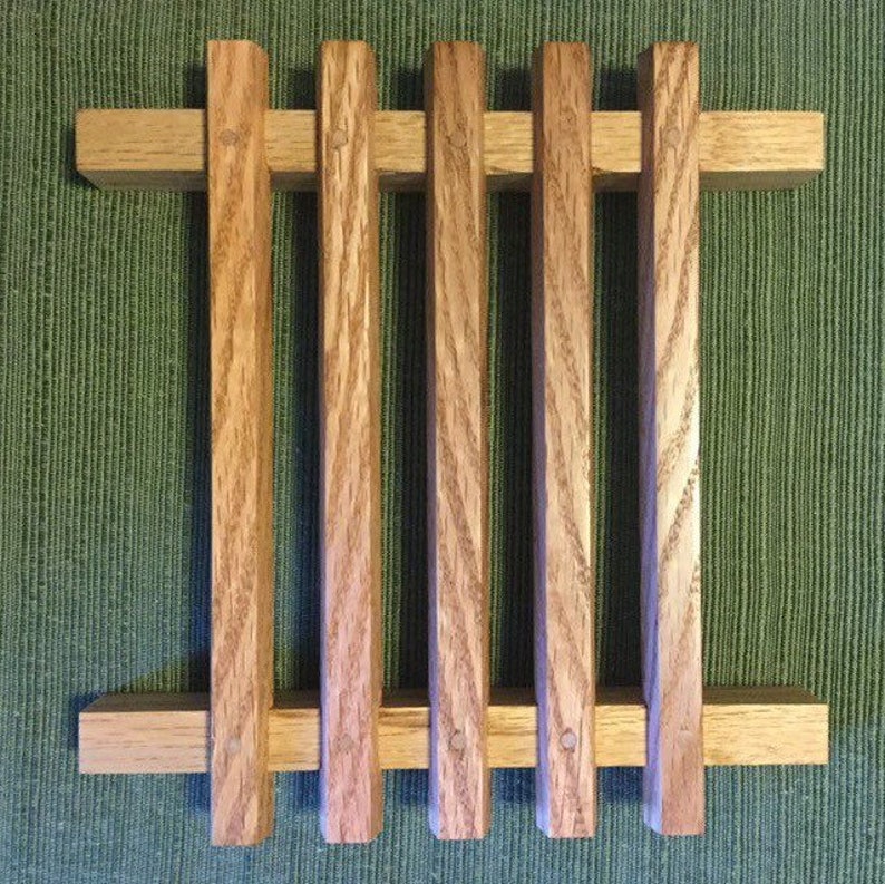 Puede incluir: Un estante de madera con cinco listones verticales y dos listones horizontales. El estante est&aacute; hecho de madera marr&oacute;n claro con un acabado natural.