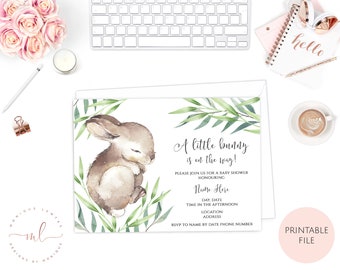 May include: A baby shower invitation with a watercolor illustration of a brown bunny sleeping on green leaves. The text reads "A little bunny is on the way!" and includes space for the guest of honor's name, date, time, location, and address.