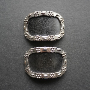 Pair of cut steel metal and black leather shoe buckles