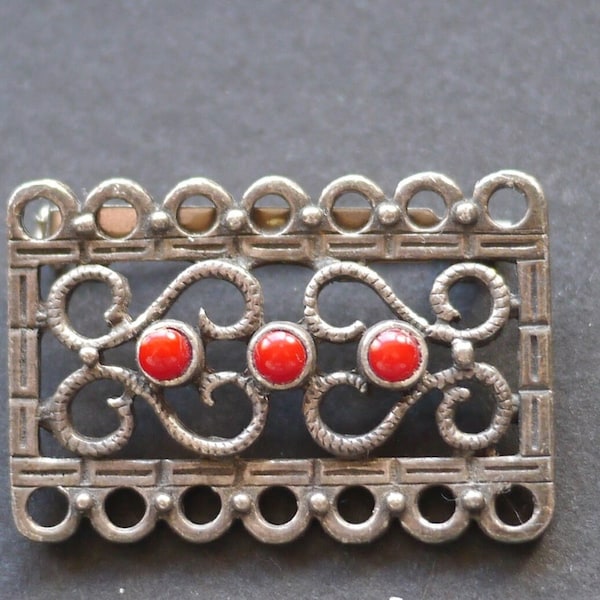 Silver tone ornate metal brooch with red beads, signed DLH