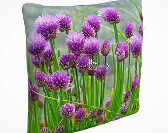 May include: A pillow with a floral print featuring a close-up of purple chive blossoms and green stems.
