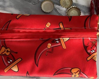 May include: A rectangular red zippered pouch featuring a repeating pattern of cartoon chili peppers wearing sombreros. The chili characters are depicted playing acoustic guitars and holding maracas against the solid red fabric background.