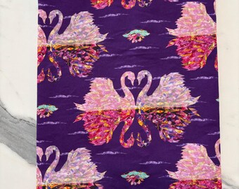May include: A rectangular fabric book cover in a deep purple hue featuring a repeating pattern of pink and orange swans with iridescent, mosaic-like wing details. A solid yellow ribbon bookmark extends from the bottom edge of the cover.