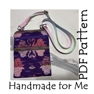 May include: A purple crossbody bag with a swan pattern, featuring a zippered main compartment and a long, adjustable strap. The bag has a decorative swan design in pink, purple, and gold. The text "Handmade for Me" and "PDF Pattern" are also visible.