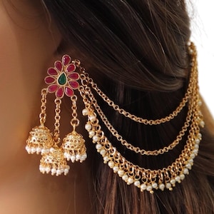 May include: Gold tone earrings with a red and green flower design, three dangling bells, and a chain with pearl accents.