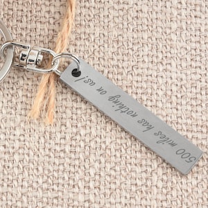 May include: Silver keyring with a rectangular tag that reads "500 miles has nothing on us!"