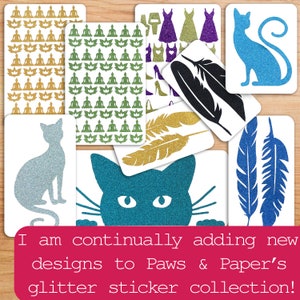 May include: Assortment of glitter stickers featuring various designs, including cats, feathers, and a repeating pattern of meditating figures. The text "I am continually adding new designs to Paws & Paper's glitter sticker collection!" is displayed at the bottom of the image.