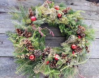 Traditioneller immergrüner Weihnachtskranz mit gesammelten Naturmoosen und Zapfen