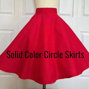 May include: A vibrant red circle skirt displayed on a mannequin. The skirt has a wide waistband and a full, flowing shape. The text "Solid Color Circle Skirts" is printed across the bottom of the skirt.
