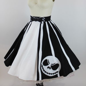 May include: A black and white striped skirt with a white bat and Jack Skellington face applique. The skirt is full and has a white petticoat underneath.