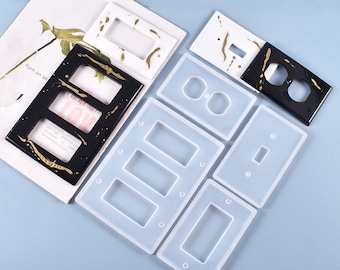 May include: A set of six silicone molds for making decorative light switch and outlet covers. The molds are white and feature different shapes for single, double, and triple switch covers.