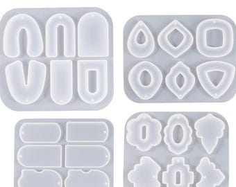 May include: Four silicone molds for making earrings. The molds are in a grid pattern and feature various shapes, including teardrop, geometric, and rectangular.