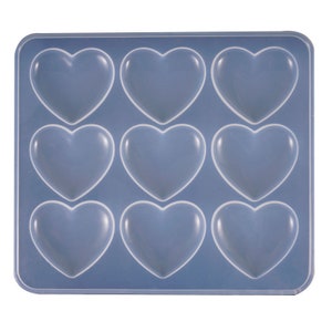 May include: A blue silicone mould with nine heart-shaped cavities. The mould is designed for making chocolates, sweets, or other treats.