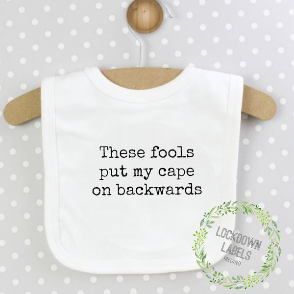 Baby Gift - These Fools Put My Cape On Backwards Baby Bib. Great for a Baby Shower Gift or New Parent Gift. Funny Baby Bib