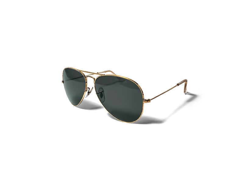May include: Gold aviator sunglasses with dark green lenses.