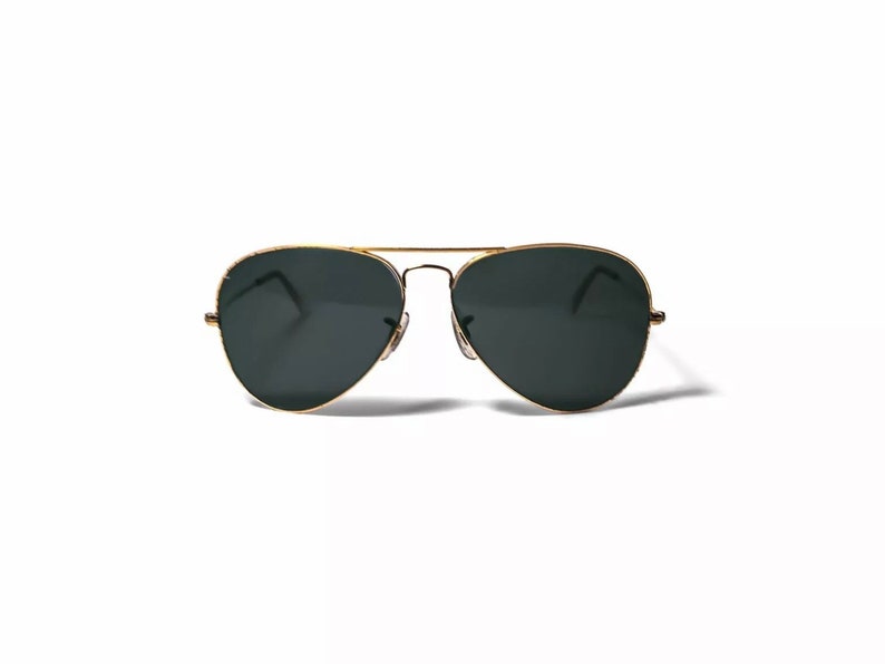 May include: Gold aviator sunglasses with dark green lenses.