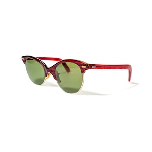 May include: Red and brown cat-eye sunglasses with green lenses.
