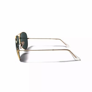 May include: Gold aviator sunglasses with green lenses. The sunglasses are shown from the side.