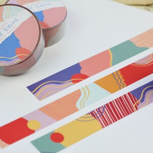 May include: Washi tape rolls with a colorful abstract pattern. The tape features a variety of shapes, lines, and colors, including red, orange, yellow, green, blue, and purple. The text on the tape reads "Happy Colorful Pattern".
