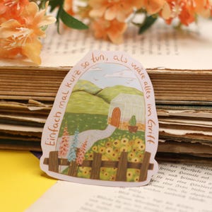 May include: A sticker depicting a garden scene with a path leading to a greenhouse, surrounded by flowers and a wooden fence. The sticker has German text that reads "Einfach mal kurz so tun, als wäre alles im Griff."