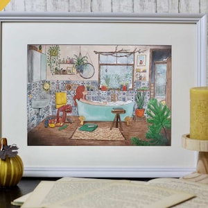 May include: A framed watercolor illustration depicts a bathroom scene with a woman in a teal bathtub. The room features patterned tiles, plants, and a window overlooking a snowy landscape. A yellow candle and a decorative pumpkin are in the foreground.