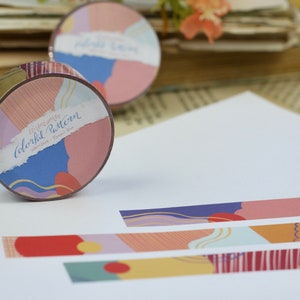 May include: A roll of washi tape with a colorful abstract pattern. The tape is labeled "Memories Colorful Pattern" and features a variety of colors, including pink, blue, yellow, and green. The tape is unrolled on a white surface, showing the pattern.