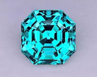 May include: A faceted, teal-colored gemstone with an octagonal shape. The gem has a complex internal structure, reflecting light to create a brilliant appearance. The bottom right corner of the image contains the text "JEFF DAVIES & SON GEMSTONES & FACETING."