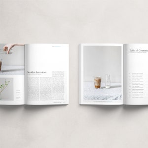 May include: An open magazine with a white background and a photo of a glass of iced coffee and a bottle of milk on a white tablecloth. The magazine's table of contents is visible on the right page, with headings such as "Sunset Boulevards", "Original Moments", "Folding Time", "Summer Wines", "Affordable Memories", "Sudden Interviews", and "New Stories".