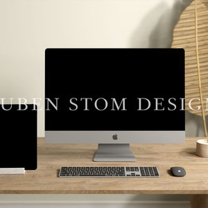 May include: A modern workspace with a silver desktop computer, a black tablet, a wireless keyboard, and a mouse on a wooden desk. The computer screen is black and the tablet screen is also black. There are two small beige candles on the desk.