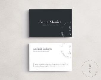 May include: Two business cards with a black and white design. The top card has the text "Santa Monica" and "The Creative Common Group". The bottom card has the text "Michael Williams" and "Senior Graphic Designer". Both cards have a circular design with the letters "S-A" and "DESIGN" in a circle.