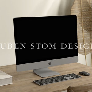 May include: A modern workspace with a silver iMac computer, a black keyboard, and a black mouse on a light wood desk. The text "RUBEN STOM DESIGN" is visible on the computer screen.