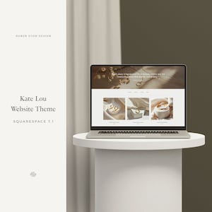 May include: A laptop computer displaying a website for a jewelry store. The website features a minimalist design with a light background and gold accents. The text on the website reads "Each piece is handpicked for its beauty, history and the meticulous detail that draws us in."