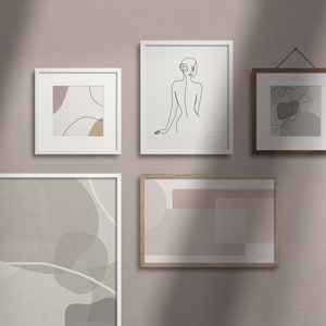 Puede incluir: Una pared de galería con cinco impresiones enmarcadas. Las impresiones presentan formas abstractas y dibujos de líneas en tonos beige, marrón y gris. Los marcos son blancos y de madera.