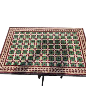 May include: A rectangular table top with a green, red, and white mosaic tile design. The table top has a decorative border.