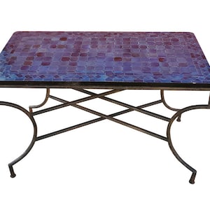 Puede incluir: Una mesa de centro rectangular con una tapa de mosaico de azulejos morados y azules y un marco de metal negro con un diseño en forma de X.