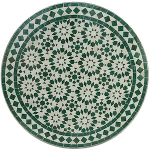 Puede incluir: Una mesa redonda de mosaico de azulejos verdes y blancos con un patrón geométrico.