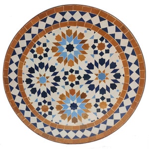 May include: A round, decorative tile with a geometric pattern in shades of blue, brown, and white. The tile features a repeating starburst design.