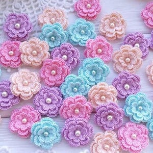 Peut inclure: Un assortiment de fleurs crochetées aux couleurs pastel, rose, violet, pêche et bleu. Chaque fleur est ornée d'une perle en son centre. Ces décorations florales faites à la main sont parfaites pour les loisirs créatifs.
