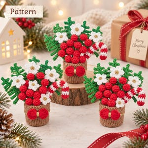 May include: Three crocheted Christmas arrangements in small brown pots, each featuring red berries, white flowers with gold centers, green pine sprigs, and a red and white striped candy cane. Each pot is decorated with a small red bow.