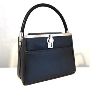 May include: A black leather handbag with a silver clasp and a top handle.