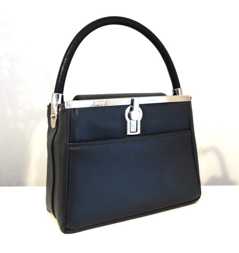 May include: A black leather handbag with a silver clasp and a top handle.