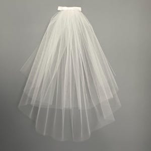 May include: A white tulle bridal veil with a satin ribbon at the top.