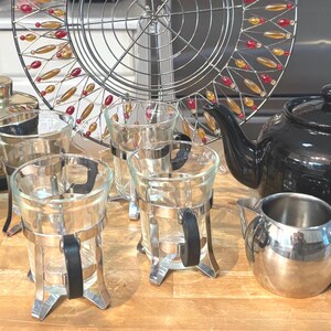 Théière noire Old Amsterdam ; vase Tour Eiffel bouton rouge ; Cartouches d'humidificateur carte du monde ; Verres à café Bodum, manchons en métal avec inserts en Duralex