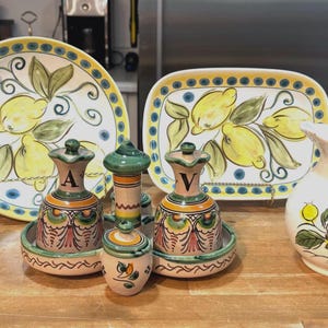 CERÁMICA VINTAGE - Platos redondos rectangulares con forma de limón, fabricados en Italia; Juego de 7 piezas de aceite y vinagre en tonos verde y marrón; Jarra y platillo, fabricados en Japón.