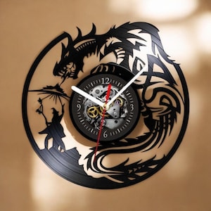 May include: A black vinyl record clock with a dragon design. The clock face is a smaller circle with a black background and silver gears. The clock hands are white and red.