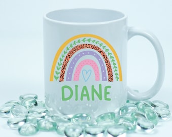 May include: White ceramic mug with a rainbow design featuring a heart and the name "DIANE" printed on the front.